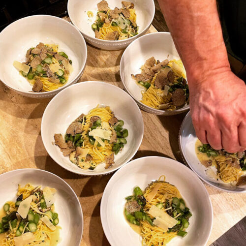 Chef Greg's hand squeezing juice on top of pasta dish with Truffles and asparagus and yummy parmesan sauce